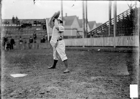 Baseball player, Jake Thiery, standing behind home plate catching a ball on a baseball field - Chicago Daily News, Inc.