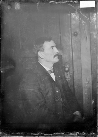 Wrestler Farmer Burns, profile view, sitting in a chair in a room - Chicago Daily News, Inc.