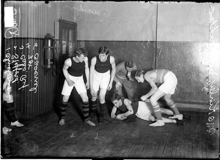 Basketball players, McKinley High School, demonstrating various defensive and offensive positions in a gymnasium - Chicago Daily News, Inc.
