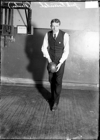 Bowler, Jack Rosendal, holding ball at thigh level in front of him with both hands, in a room - Chicago Daily News, Inc.