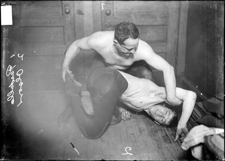 Wrestlers, Olson and Pardello, Pardello is holding Olson's foot and arm, in a room in the Chicago Daily News building - Chicago Daily News, Inc.