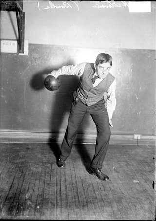 Bowler, J. H. Stevens, ball drawn behind his back in a position as if he is preparing to release it in a room - Chicago Daily News, Inc.