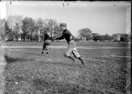 Notre Dame High School football player Purcell, kicking a football on an athletic field - Chicago Daily News, Inc.