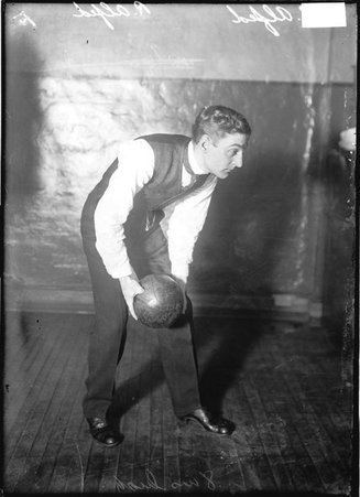 Bowler, R. Alfred, leaning over holding ball with both hands in a room - Chicago Daily News, Inc.