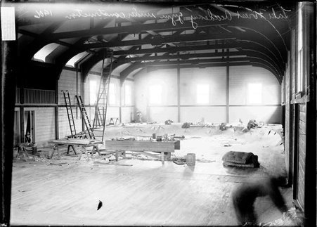 Lake Forest Academy gymnasium under construction in Lake Forest, Illinois, ladders and materials are spread throughout the interior - Chicago Daily News, Inc.