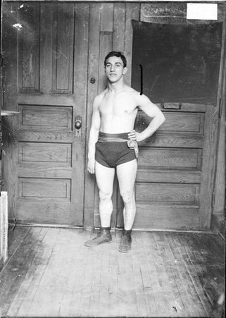 Boxer, Kid Herman, standing in a room with left hand on hip in the Chicago Daily News building - Chicago Daily News, Inc.