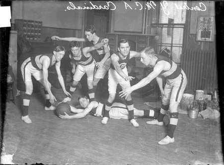 Basketball team, Central YMCA Cardinals, in defensive positions, in a room - Chicago Daily News, Inc.