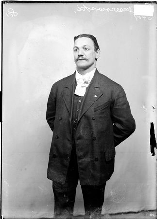 Basketball player Richard Genserowski, standing in front of a light-colored backdrop in a room - Chicago Daily News, Inc.