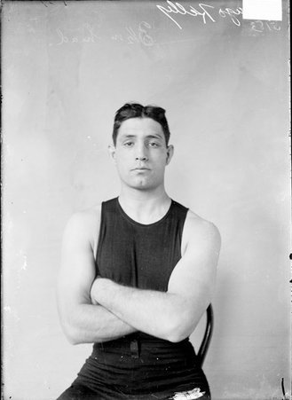 Boxer, Hugo Kelly, sitting in chair with arms crossed - Chicago Daily News, Inc.