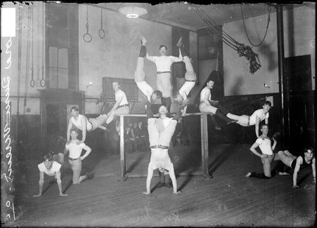 Gymnasts, Aurora Turn Verein, posing on and around even bars in a gymnasium - Chicago Daily News, Inc.