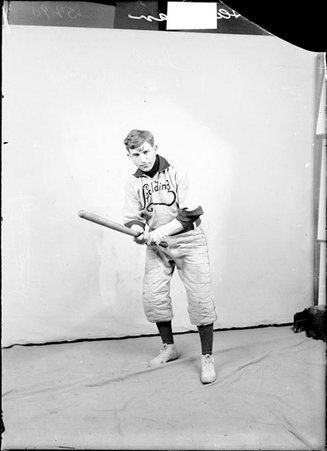 Indoor baseball players, Spalding, Victor Hausman, holding bat in front of a light colored backdrop in a room - Chicago Daily News, Inc.