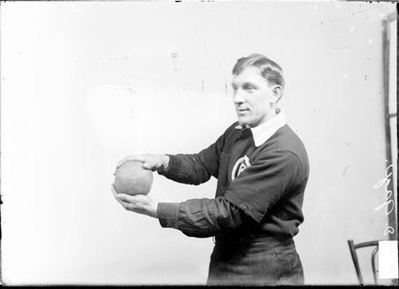 Indoor baseball player M. D. Gage, holding an indoor baseball out at his side with both hands, standing in front of a light-colored backdrop - Chicago Daily News, Inc.