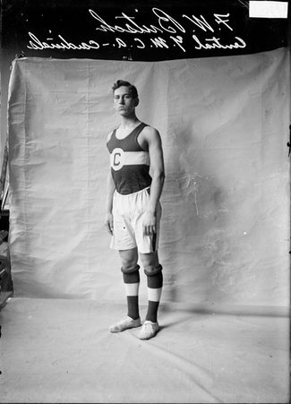 Basketball player, Central YMCA Cardinals, F. W. Britsch, turning slightly to the side in front of a light colored back drop - Chicago Daily News, Inc.