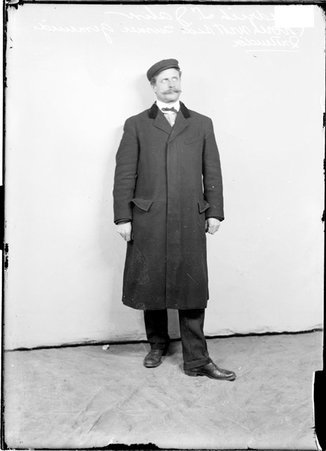 Northwest Side Turngemeinde instructor Frederick L. Jahn, wearing a hat, standing in front of a light-colored backdrop - Chicago Daily News, Inc.