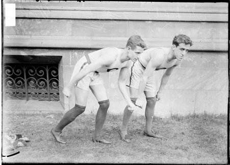 University of Chicago athletes Barker and Quigley, standing in ready positions in front of a University of Chicago building - Chicago Daily News, Inc.