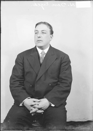 Coach E. H. Den Eyck, looking to his right, sitting in front of a light-colored backdrop in a room - Chicago Daily News, Inc.