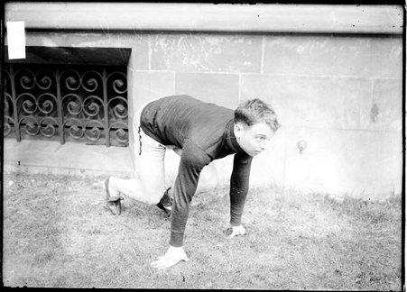 University of Chicago athlete Walter Steffen, crouching in a ready position in front of a building on the University of Chicago campus - Chicago Daily News, Inc.