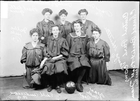 Central Park Congregational girls' basketball team sitting and standing in front of a light-colored backdrop in a room - Chicago Daily News, Inc.