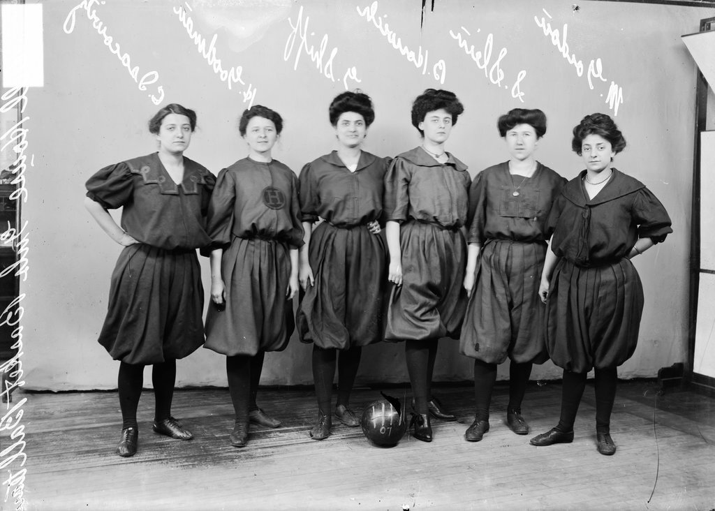 Hull House girls' basketball players Isacowits, Goodman, Shiff, Horwich, Slein, and Gordon, standing in front of a backdrop - Chicago Daily News, Inc.