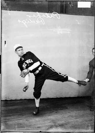 Baseball player, Pedigo, First Presbyterian Church, posing in pitching stance against backdrop - Chicago Daily News, Inc.