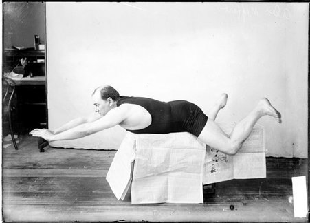 Swimming coach, C. A. A., Meffert posing, lying on his stomach, extending his arms, bending his legs - Chicago Daily News, Inc.