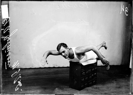 Swimmer, C. A. Johnson, N.I.A.C., posing as if swimming against backdrop - Chicago Daily News, Inc.
