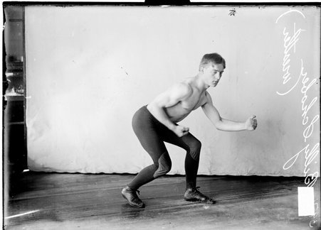 Wrestler, Billy Schober, facing right, posed crouching in wrestling position - Chicago Daily News, Inc.