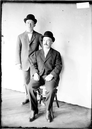 Pugilist, Dick Hyland, standing next to his manager who is sitting against backdrop - Chicago Daily News, Inc.