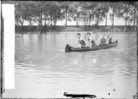 Rowers, Chicago Rowing Club, holding oars, sitting in a canoe on a body of water - Chicago Daily News, Inc.
