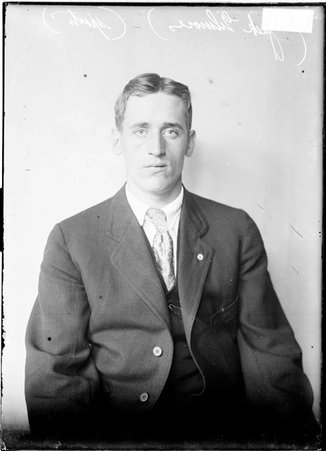 Jack Gilmore facing the camera, sitting against backdrop, dark exposure - Chicago Daily News, Inc.