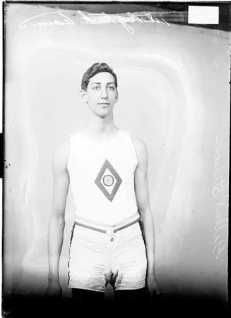 Athlete, Gilbert Stadeker, standing in front of a light colored background in a room - Chicago Daily News, Inc.