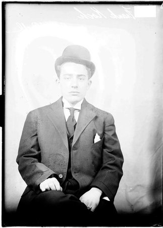 Basketball player, Frank Koch, wearing a suit, sitting in front of a light colored background - Chicago Daily News, Inc.