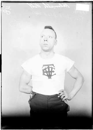 Wrestling coach, Einegkeit Helmuth Witt, standing in front of a light colored background - Chicago Daily News, Inc.