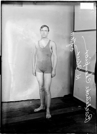 Backstroke champion swimmer, H. Olsen, of the Central YMCA, standing in front of a light colored background in a room - Chicago Daily News, Inc.