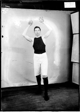 Christ Church basketball player H. Marbach, standing with his arms above his head in front of a light colored background - Chicago Daily News, Inc.