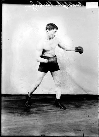 Boxer Rudolph Unholz, throwing a right jab standing in front of a backdrop - Chicago Daily News, Inc.