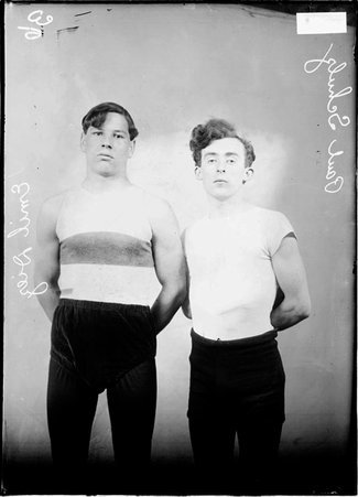 Wrestlers, Emil Diez and Paul Schultz, standing in a room with their arms behind their backs - Chicago Daily News, Inc.