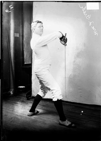 Fencer William F. Grebe, standing, right side to the camera, with his foil turned downward - Chicago Daily News, Inc.