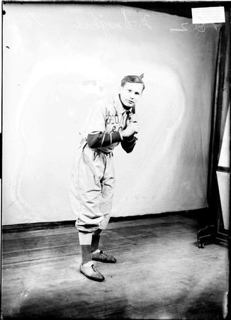 George Young & Co. indoor baseball player Smejkal, holding a bat over his shoulder standing in front of a backdrop - Chicago Daily News, Inc.