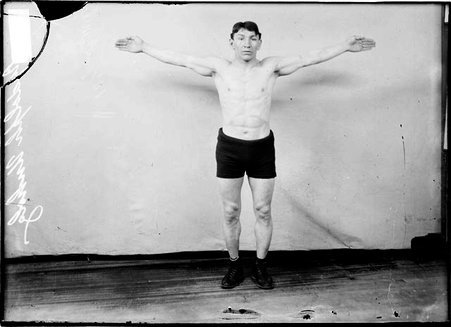 Boxer Rudolph Unholz, with his arm straight out to the side, without gloves - Chicago Daily News, Inc.