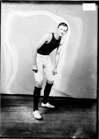 Christ Church basketball player R. Freiderici, standing, leaning forward in front of a light colored background - Chicago Daily News, Inc.