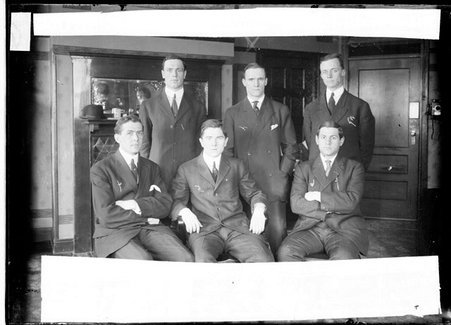University of Pennsylvania basketball players wearing suits and posing in a room - Chicago Daily News, Inc.
