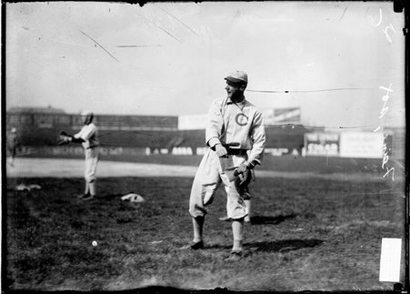 White Sox baseball player Lou Fiene, standing on the field with his arms in front of him after throwing a ball at South Side Park - Chicago Daily News, Inc.