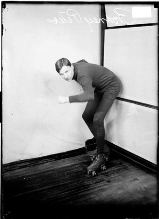Roller skater Rodney Peters, wearing roller skates, a sweater and leggings, posing with his left side to the camera - Chicago Daily News, Inc.