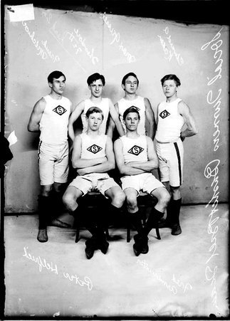 Social Turners basketball players, posing in front of backdrop, Peter Helfried and Fred Armbruster in foreground - Chicago Daily News, Inc.