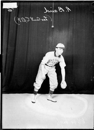 Leo Court C. O. F. indoor baseball player R. Baird, holding an indoor baseball and leaning forward, standing in front of a backdrop - Chicago Daily News, Inc.