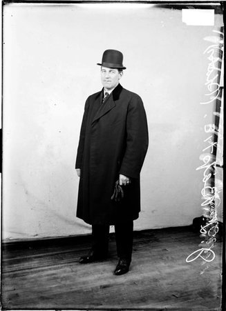 Roller skater J. L. Baptie, standing in front of a light colored background in a room - Chicago Daily News, Inc.