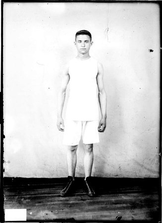 Athlete Pete Kolius, standing in front of a light colored background in a room, slightly lighter image - Chicago Daily News, Inc.