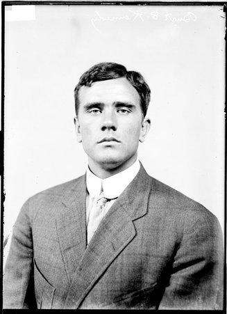 Burt E. Kennedy, facing the camera, sitting in front of a light-colored backdrop in a room - Chicago Daily News, Inc.