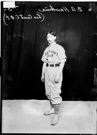 Leo Court C. O. F. indoor baseball player E. A. Hawkins, standing in front of a dark backdrop in a room - Chicago Daily News, Inc.